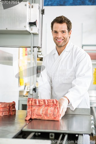 Image of Butcher Slicing Meat On Bandsaw