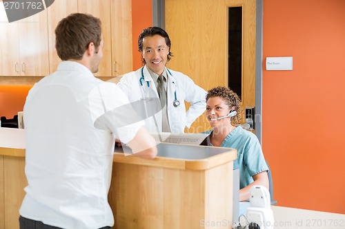 Image of Medical Team With Patient At Reception Desk