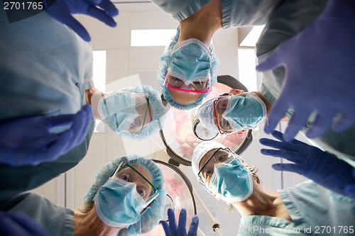 Image of Multiethnic Medical Team With Masks And Scrubs In Operation Room