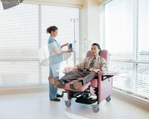 Image of Nurse Operating IV Machine For Patient During Chemotherapy