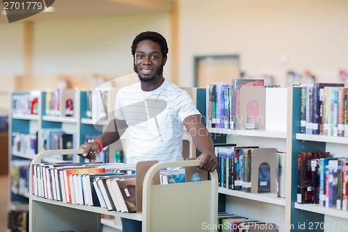 Image of Librarian With Trolley Of Books In Library