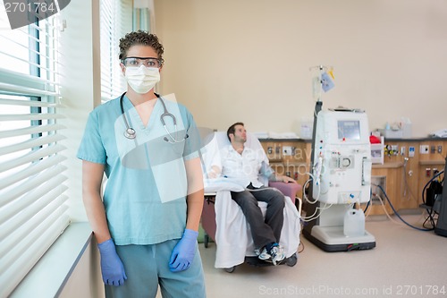 Image of Nurse In Protective Clothing With Patient Receiving Dialysis