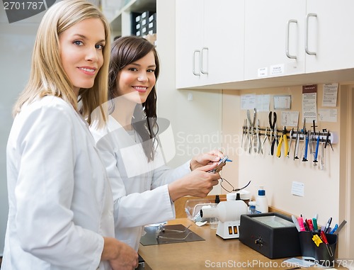 Image of Happy Opticians Repairing Glasses In Workshop