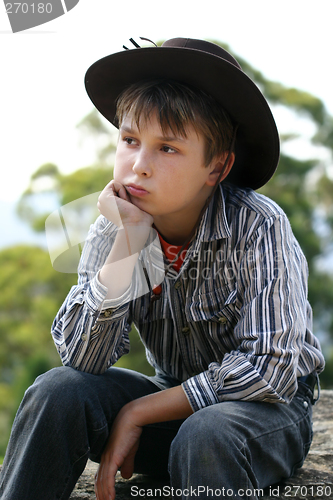 Image of Country cowboy sitting on a rock