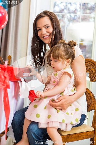 Image of Mother With Birthday Girl Opening Present