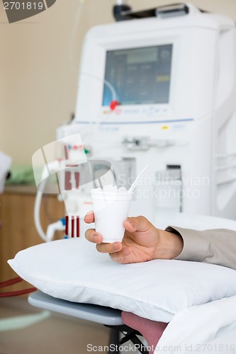 Image of Patient Holding Glass Of Crushed Ice In Dialysis Room