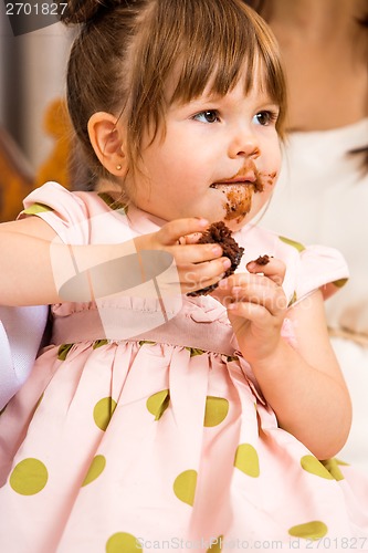 Image of Birthday Girl Eating Cake With Icing On Her Face