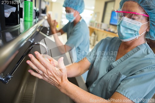 Image of Female Surgeon Scrubbing Hands and Arms