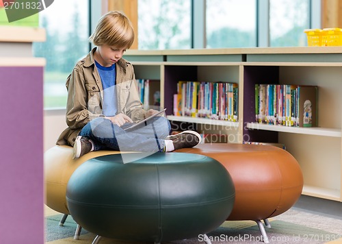 Image of Schoolboy Using Digital Tablet In Library