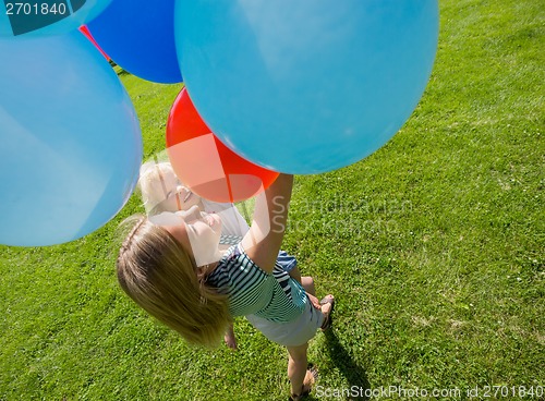 Image of Mother And Daughter Holding Colorful Balloons In Park