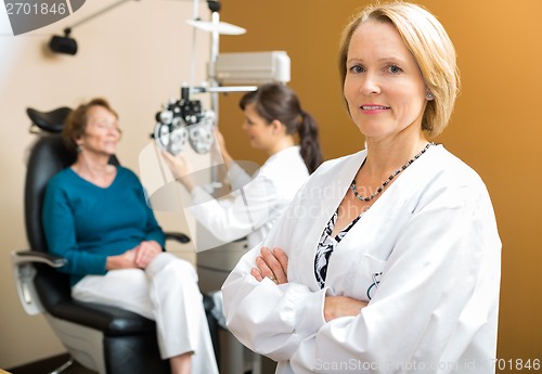 Image of Confident Ophthalmologist With Colleague Examining Patient