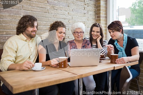 Image of Woman With Friends Using Laptop At Coffeeshop