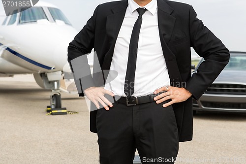 Image of Entrepreneur Standing In Front Of Private Jet And Car