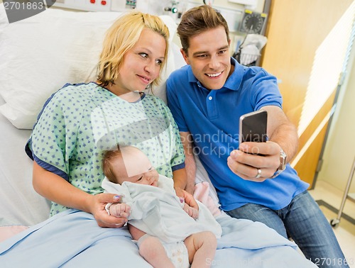 Image of Man With Woman And Babygirl Taking Selfportrait Through Mobile P