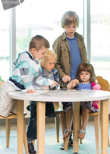 Image of Children Using Tablet Computer At Desk In Library