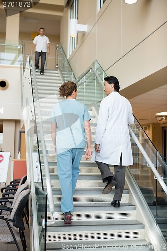 Image of Doctor And Nurse Climbing Up Stairs In Hospital