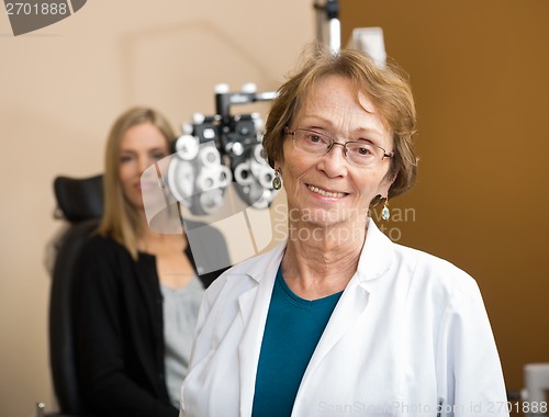 Image of Female Optometrist With Patient In Background