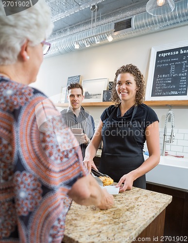 Image of Workers Looking At Senior Woman In Cafeteria