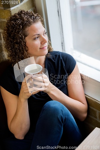 Image of Woman Looking Through Window In CafÃ©