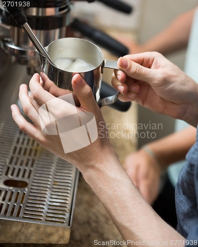 Image of Barista Steaming Milk In Coffeeshop