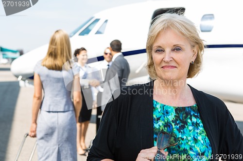 Image of Portrait Of Confident Businesswoman Against Private Jet