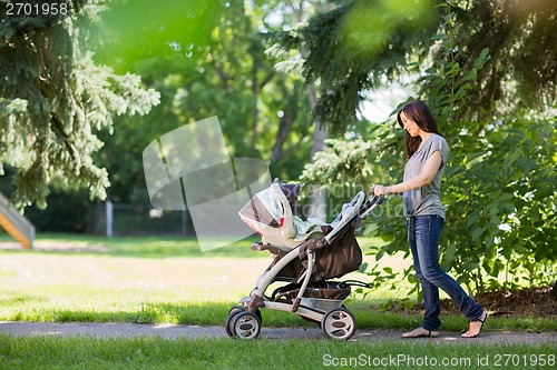 Image of Mother Pushing Stroller In The Park