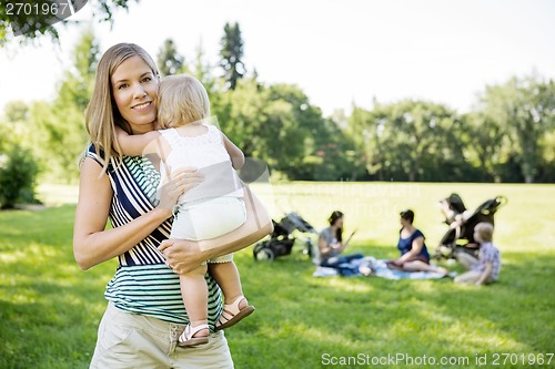 Image of Happy Mother Carrying Daughter At Park