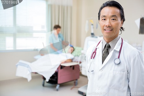 Image of Doctor In Hospital Room With Nurse Giving Dialysis To Patient