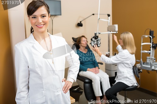Image of Confident Optometrist With Colleague Examining Patient