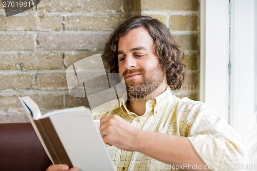 Image of Man Reading Book In Coffeeshop