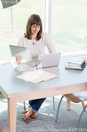 Image of Student Using Technologies While Studying In Library