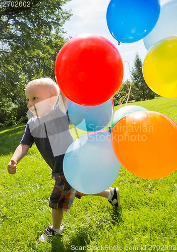 Image of Happy Boy With Balloons Walking In Park