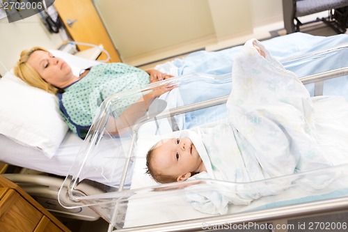 Image of Babygirl Lying In Bassinet With Woman On Hospital Bed