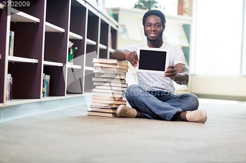 Image of Smiling Student With Books Showing Digital Tablet In Library