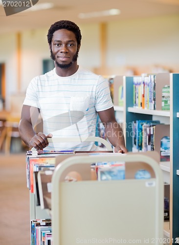 Image of Librarian With Trolley Of Books In Library