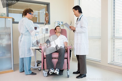 Image of Patient Looking At Doctor Holding Digital Tablet In Hospital Roo