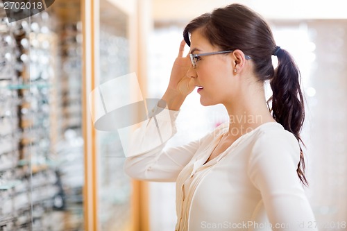 Image of Woman Trying New Glasses At Optician Store