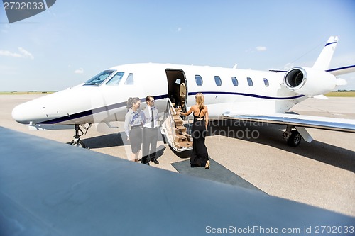 Image of Elegant Woman Boarding Private Jet At Terminal