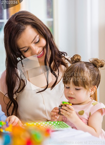 Image of Mother With Birthday Girl Eating Cupcake