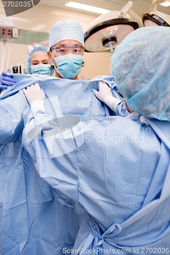 Image of Surgeon Putting on Sterile Surgical Gown