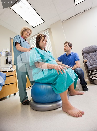 Image of Nurse Assisting Pregnant Woman Sitting On Pilate Ball