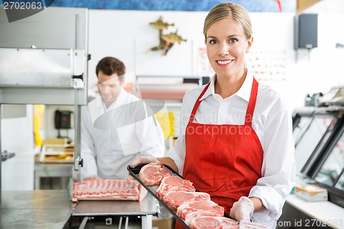 Image of Beautiful Butcher Holding Meat Tray In Store