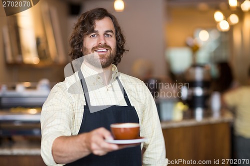 Image of Confident Waiter Holding Coffee Cup In Cafe