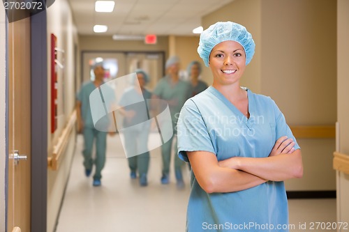 Image of Surgeon Standing Arms Crossed In Hospital Corridor