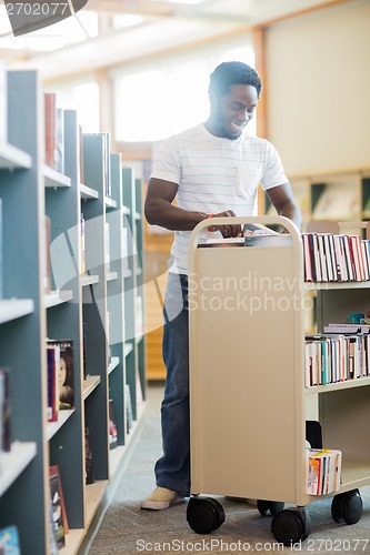 Image of Librarian With Trolley Of Books Working In Library