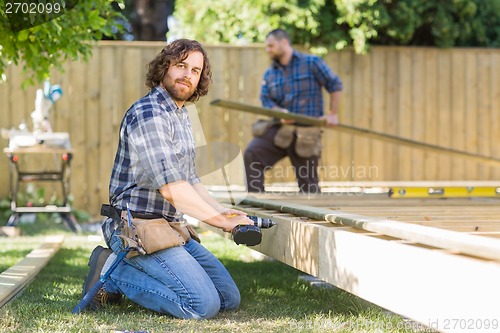 Image of Worker Drilling Wood At Construction Site