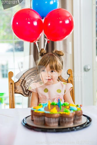 Image of Girl Licking Lips In Front Of Birthday Cake