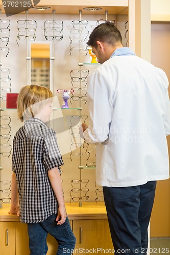 Image of Optometrist And Boy Choosing Eyewear In Store