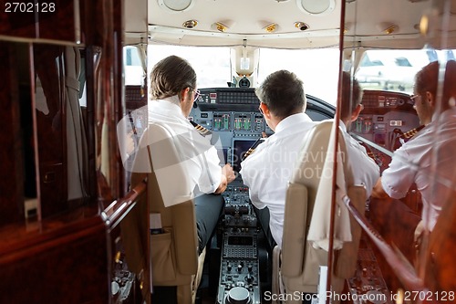 Image of Pilots Operating Controls Of Private Jet