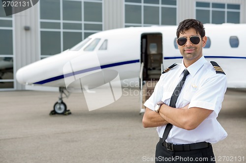 Image of Pilot With Arms Crossed Standing In Front Of Private Jet